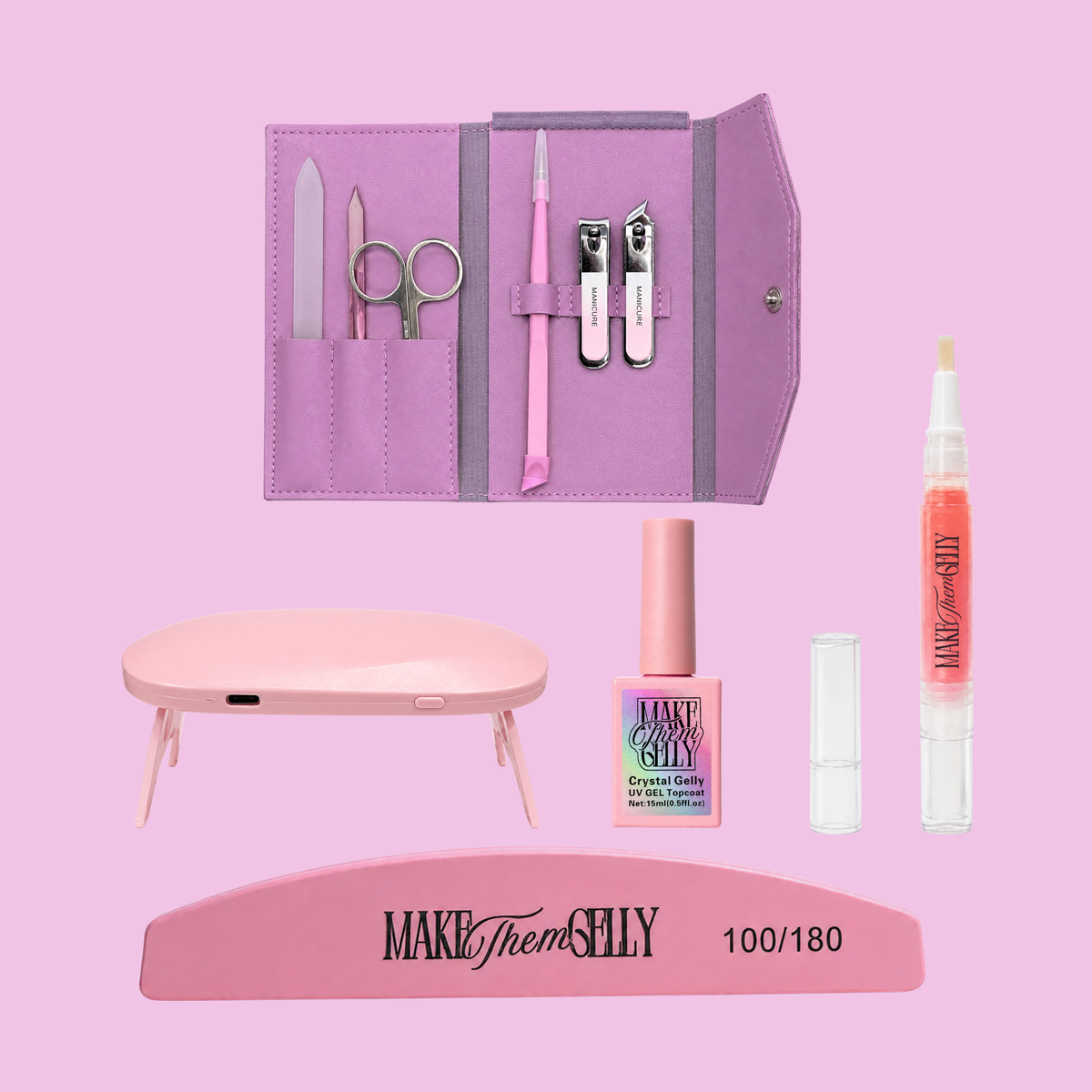 Make Them Shelly nail kit arranged on a solid pink background, including a lavender zip case with nail tools, a pink nail file, nail scissors, cuticle tool, nail polish, gel nail polish, a clear tube, and a pink press-on nail tray.